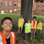 5 smiling people in reflective vests, Ren on the left in the foreground, then four people together by a tree: Mackenzie, Lucie, Maggio, and Chloe